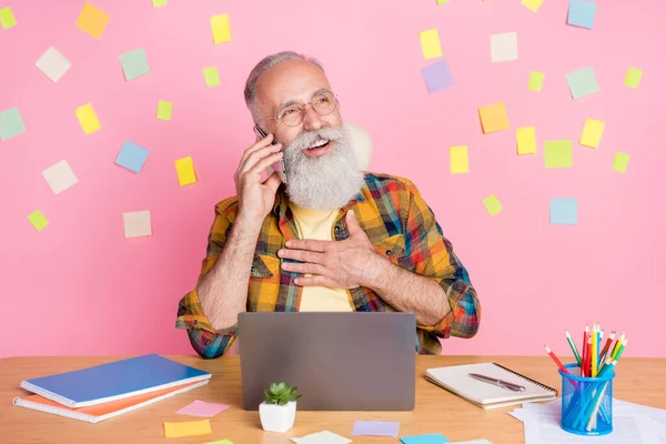 Photo de joyeux gris barbe vieux homme parler téléphone travail ordinateur portable porter chemise lunettes isolé sur fond de couleur rose — Photo