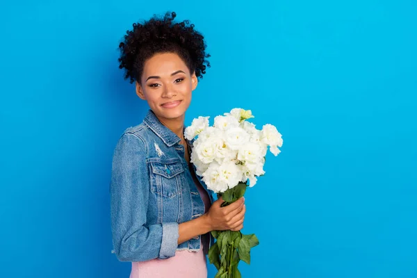 쾌활 한 젊고 행복 한 미국 여성의 사진 손에 꽃을 들고 푸른 색 배경에 고립된 기분좋은 기분 — 스톡 사진
