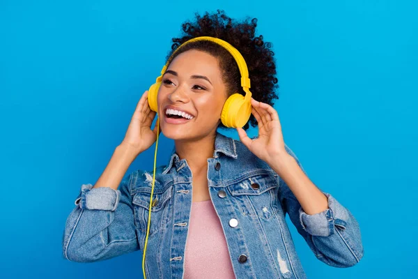 Photo de rêve joyeux jeune femme heureuse porter des écouteurs regarder espace vide isolé sur fond de couleur bleue — Photo