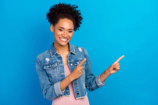 Foto av positiva unga glada afro amerikanska kvinna peka finger tomt utrymme försäljning isolerad på blå färg bakgrund — Stockfoto