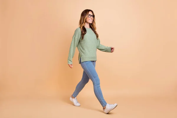 Longitud completa cuerpo tamaño foto mujer usando gafas casual traje caminando aislado pastel beige color fondo —  Fotos de Stock