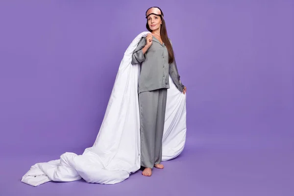 夢のような若い女性の完全な長さの写真は、ナイトウェアを着用見て空のスペースは紫色の背景に隔離された毛布を保持 — ストック写真