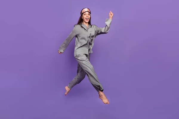 Pleine longueur taille du corps vue de jolie pied nu femme gaie sautant marcher isolé sur violette fond de couleur pourpre — Photo