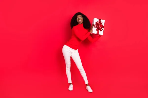 若い黒の女性の完全な長さの写真幸せな正笑顔ホールドギフトボックス興奮パーティー孤立以上赤色の背景 — ストック写真