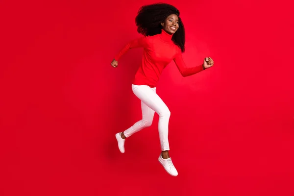 Полный профиль тела стороне фото молодой афро-женщина счастливый позитивный прыжок улыбка вверх идти бежать бежать Спешите продажи изолированы на красный цвет фона — стоковое фото