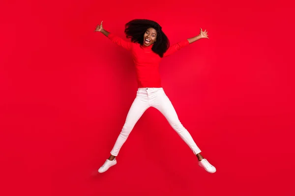 若いアフリカ人女性のフルサイズの写真幸せな正の笑顔持っています楽しいジャンプアップファンキーな孤立した上赤い色の背景 — ストック写真