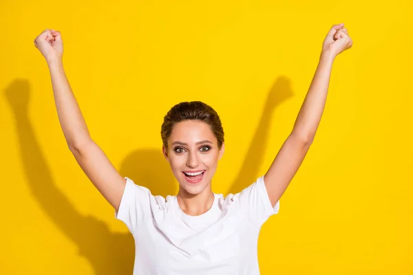 Foto av Hurra brun kort frisyr ung dam händer upp bära vit t-shirt isolerad på gul färg bakgrund — Stockfoto