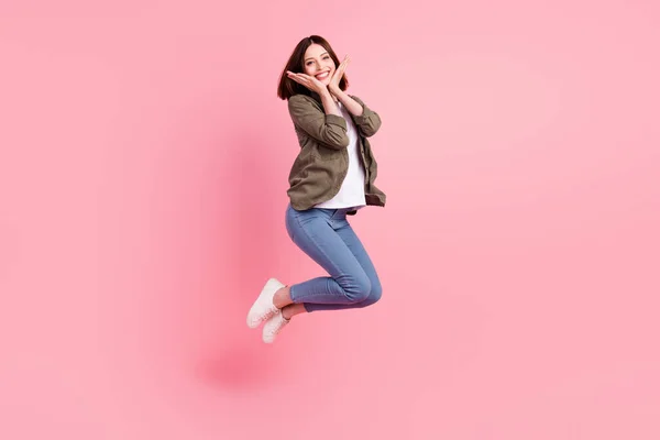 Full body foto van onder de indruk kort kapsel dame springen dragen kaki shirt jeans sneakers geïsoleerd op roze kleur achtergrond — Stockfoto