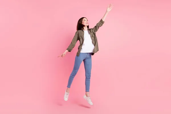 Full body foto van mooie korte kapsel dame dans look up dragen kaki shirt jeans sneakers geïsoleerd op roze kleur achtergrond — Stockfoto