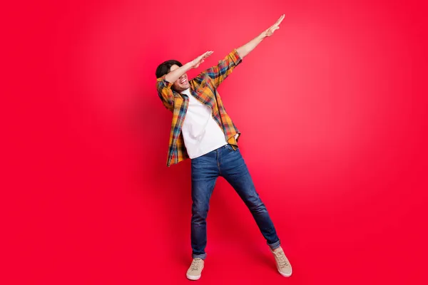 Foto von süßen lustigen jungen Herrn tragen kariertes Outfit lächelnd tanzen isoliert rote Farbe Hintergrund — Stockfoto
