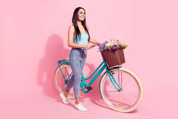 Comprimento total tamanho do corpo vista de menina alegre atraente andando de bicicleta tempo livre isolado sobre cor de fundo pastel rosa — Fotografia de Stock