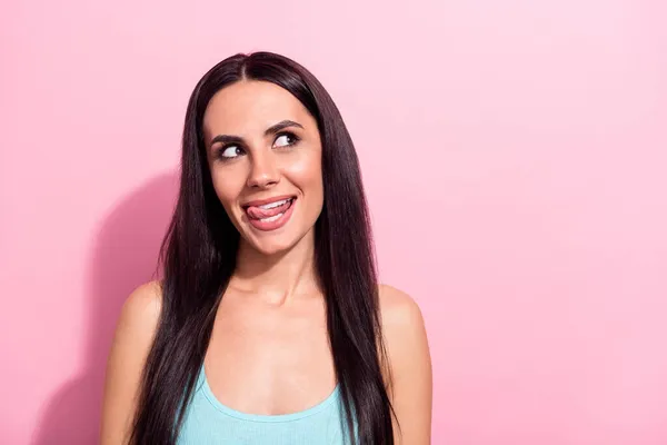 Foto portret van nieuwsgierige brunette likken lip kijken copyspace geïsoleerd op pastel roze kleur achtergrond — Stockfoto