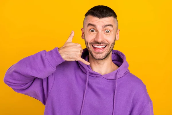 Fénykép vicces fiatal brunet srác hívjon visel lila kapucnis elszigetelt sárga színű háttér — Stock Fotó