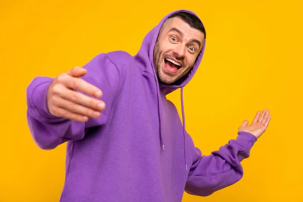 Photo of funky young brunet guy wear violet hoodie isolated on yellow color background — Stock Photo, Image