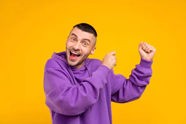 Photo de jeune gai funky positif homme danse profiter porter violet sweat à capuche cool isolé sur fond de couleur jaune — Photo
