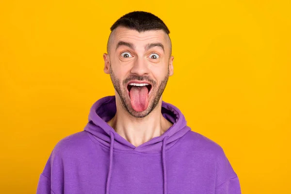 Foto ritratto giovane uomo che indossa pullover viola ingannare mostrando lingua isolato luminoso colore giallo sfondo — Foto Stock