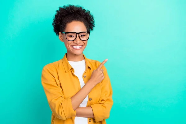 Portret van aantrekkelijke vrolijke meisje tonen kopiëren lege ruimte geïsoleerd over levendige teal turquoise kleur achtergrond — Stockfoto