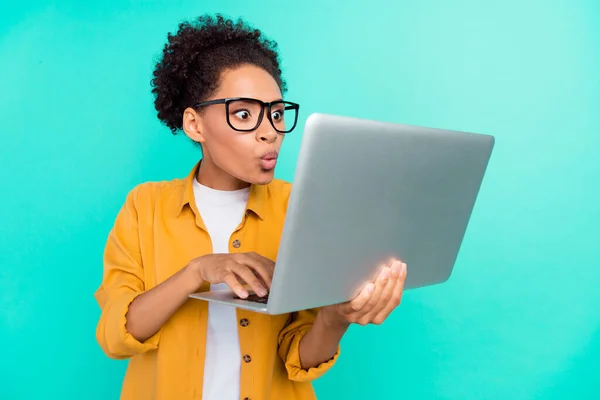 Portret van aantrekkelijke funky verbaasd meisje met behulp van laptop pruillip wow geïsoleerd over heldere teal turquoise kleur achtergrond — Stockfoto