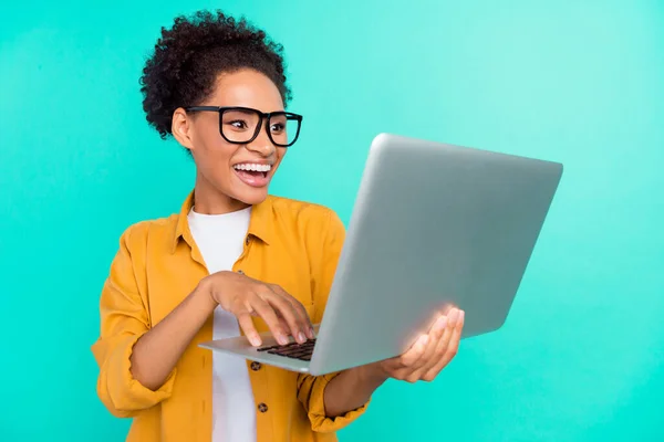 Foto portret meisje dragen bril werken op computer typen bericht geïsoleerde levendige teal kleur achtergrond — Stockfoto