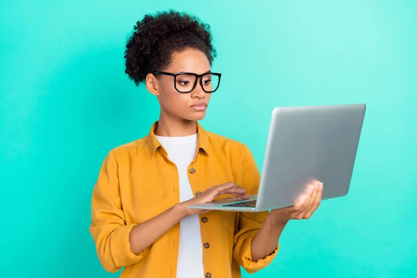 Foto retrato menina encaracolado penteado usando óculos usando laptop isolado vivid teal cor de fundo — Fotografia de Stock