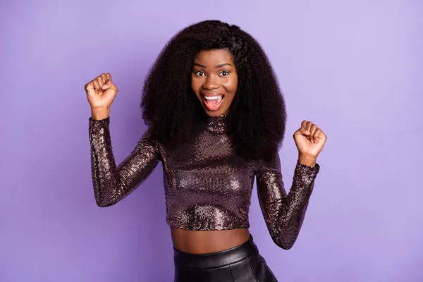 Foto av unga attraktiva glada glada glada afrikanska flicka hålla nävar i seger isolerad på violett färg bakgrund — Stockfoto
