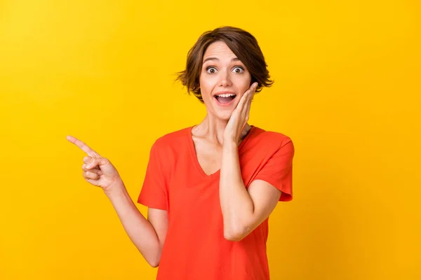 Retrato de bom morena impressionado senhora ponto vazio espaço desgaste vermelho t-shirt isolado no vívido amarelo cor fundo — Fotografia de Stock