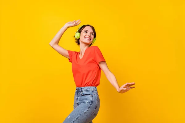 Retrato de chica alegre mirada espacio vacío sonrisa dentada escuchar favorito solo aislado sobre fondo de color amarillo — Foto de Stock