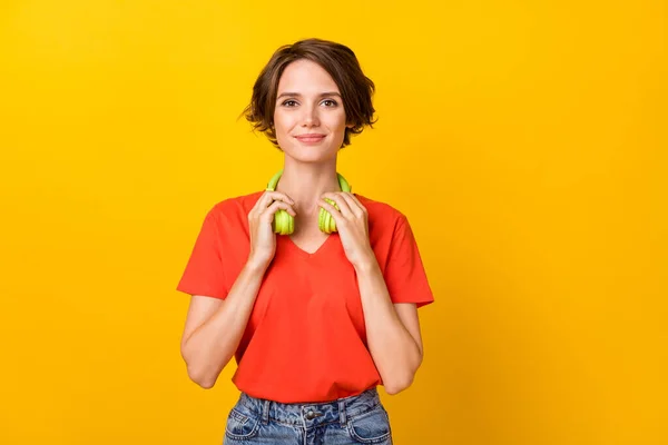Foto de senhora morena agradável otimista usar fones de ouvido camiseta laranja isolada no fundo amarelo — Fotografia de Stock