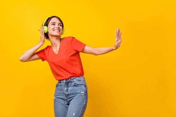 Retrato de persona bastante positiva mirada espacio vacío divertirse escuchar pista favorita aislado sobre fondo de color amarillo — Foto de Stock