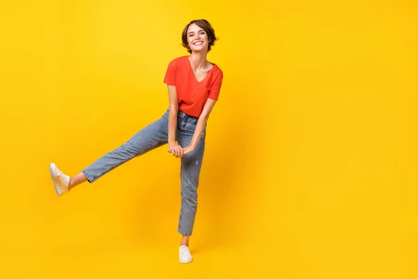 Foto de tamaño completo de la fresca morena optimista dama danza desgaste rojo camiseta jeans zapatillas aisladas sobre fondo de color amarillo —  Fotos de Stock