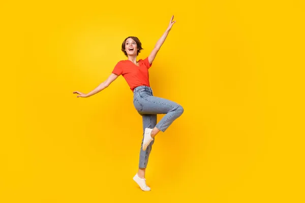 Full size foto van vrolijk meisje kijken leeg ruimte verhogen hand knie hebben goed humeur geïsoleerd op gele kleur achtergrond — Stockfoto
