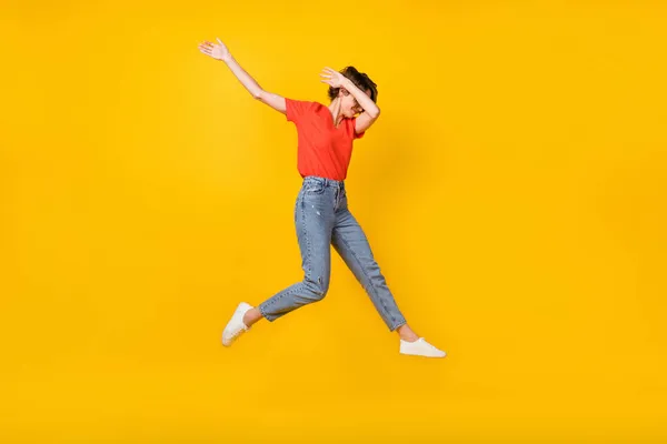 Foto de perfil de tamaño completo de la optimista morena peinado corto señora salto danza desgaste camiseta jeans zapatillas aisladas sobre fondo amarillo —  Fotos de Stock