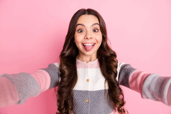 Çekici bir genç kızın fotoğrafı mutlu mutlu bir gülümseme suratını ekşiten dil çıkartan pembe renkli arka planda izole edilmiş selfie blogcusu. — Stok fotoğraf
