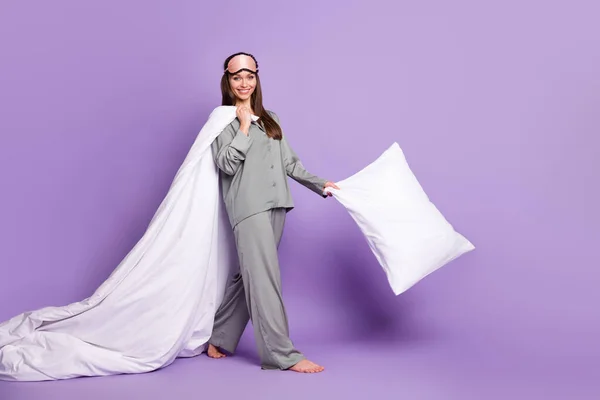 Tamanho total do corpo foto de menina no pijama andando máscara de dormir mantendo manta de travesseiro branco isolado fundo cor violeta pastel — Fotografia de Stock