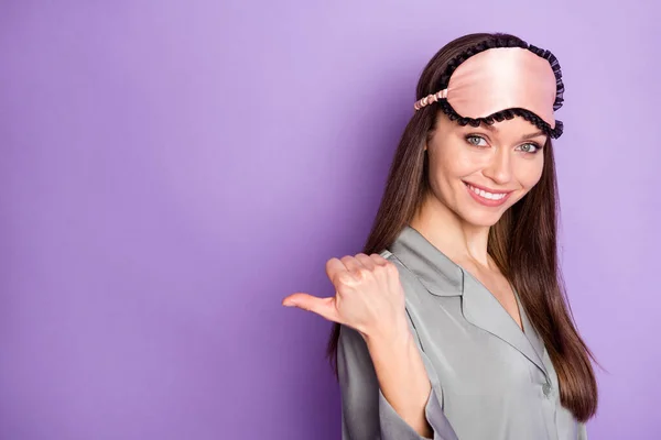 Profiel zijaanzicht portret van aantrekkelijke trendy vrolijke meisje dragen pyjama demonstreren kopiëren ruimte ad geïsoleerd over violet paarse kleur achtergrond — Stockfoto