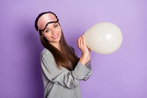 Фотопортрет красивой девушки в пижамной маске, держащей воздушный шар на день рождения изолирован на пастельно-фиолетовом фоне — стоковое фото