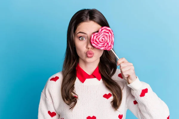 Фото смешной кокетливой юной леди носить сердца печать свитера обложка глаза конфеты губы надутые изолированные синий цвет фона — стоковое фото