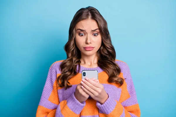 Porträt von attraktiven besorgten Mädchen mit Gerät lesen gefälschte Nachrichten Post Abneigung isoliert über helle blaue Farbe Hintergrund — Stockfoto