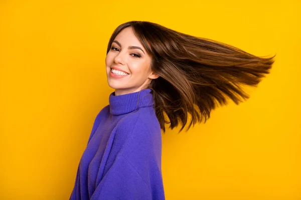 Foto van charmante glanzende jonge vrouw dragen paarse pullover glimlachen lucht blazen haar geïsoleerde gele kleur achtergrond — Stockfoto