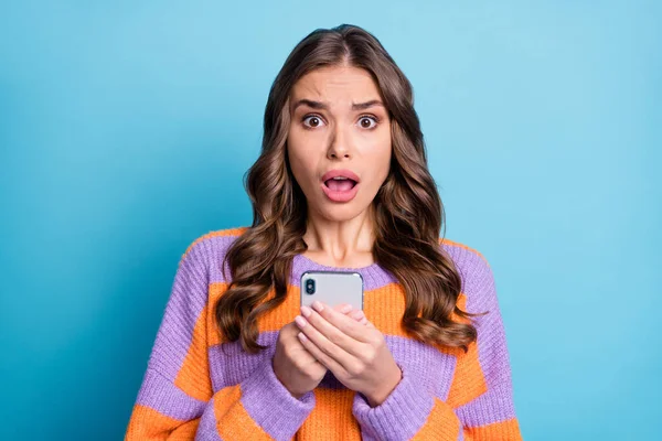 Portré lenyűgözött személy tartsa telefon nyitott szájú bámuló kamera kopás pulóver elszigetelt kék színű háttér — Stock Fotó