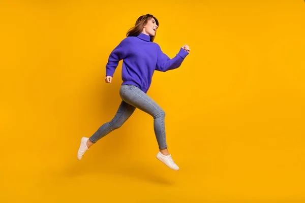 Foto de la joven adorable funky vestido suéter violeta saltando corriendo rápido aislado color amarillo fondo — Foto de Stock