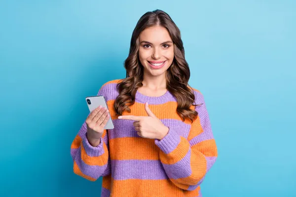 Portret van aantrekkelijke vrolijke meisje houden in de hand demonstreren apparaat advertentie geïsoleerd over helder blauwe kleur achtergrond — Stockfoto