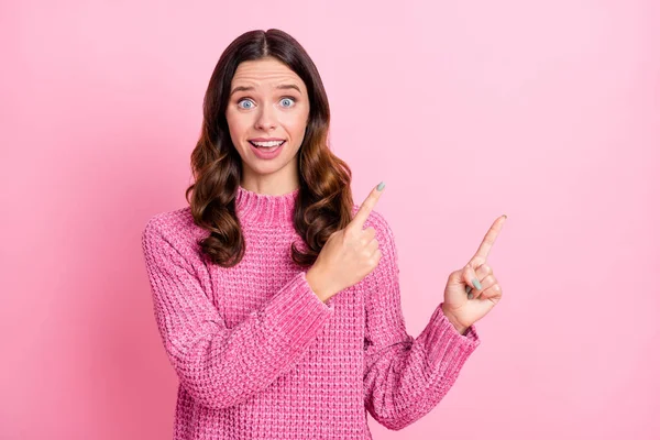 Retrato de chica de pelo ondulado alegre atractiva asombrada mostrando copia anuncio de espacio vacío aislado sobre fondo de color pastel rosa —  Fotos de Stock