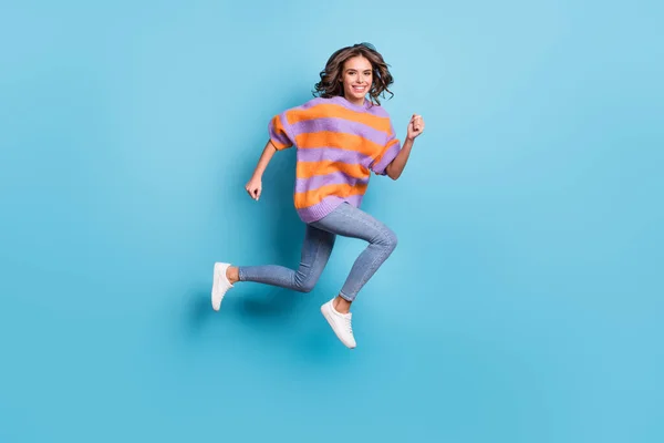 Повнометражний вигляд на тіло чарівна активна весела дівчина, що стрибає ізольовано на яскраво-блакитному фоні — стокове фото