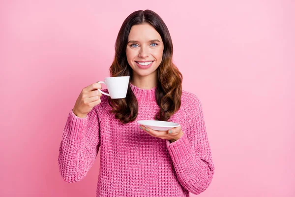 Portrait d'une jolie fille aux cheveux ondulés et joyeux buvant une boisson amoureuse de caféine isolé sur fond rose pastel — Photo