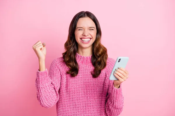 Zdjęcie hura miły brunetka pani trzymać telefon nosić różowy sweter izolowany na pastelowy różowy kolor tła — Zdjęcie stockowe
