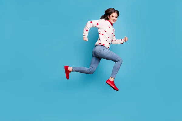 Lunghezza completa foto di dolce giovane donna vestita cuori stampa pullover corsa salto alto isolato colore blu sfondo — Foto Stock