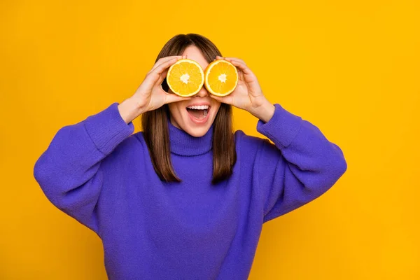 Portré vonzó bolond vidám lány gazdaság narancssárga szeletek csukott szemmel szórakozás jó hangulat elszigetelt felett élénk sárga színű háttér — Stock Fotó