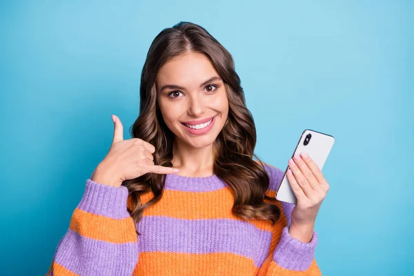 Portret van aantrekkelijke vrolijke meisje met behulp van apparaat tonen bel me gebaar geïsoleerd over helder blauwe kleur achtergrond — Stockfoto