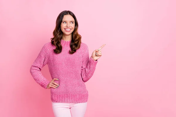 Foto de otimista agradável morena senhora ponto olhar espaço vazio desgaste rosa suéter isolado no fundo cor-de-rosa pastel — Fotografia de Stock